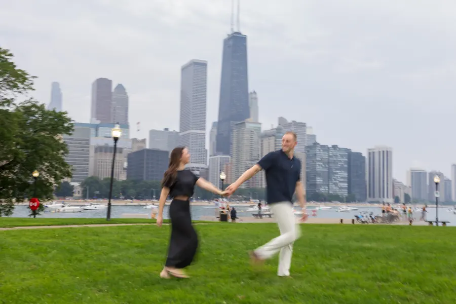 A couple dancing on the lakefront lawn with the Chicago skyline behind them