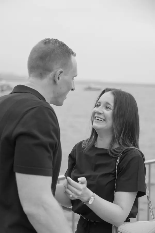 Black and white portrait of a newly engaged couple laughing together