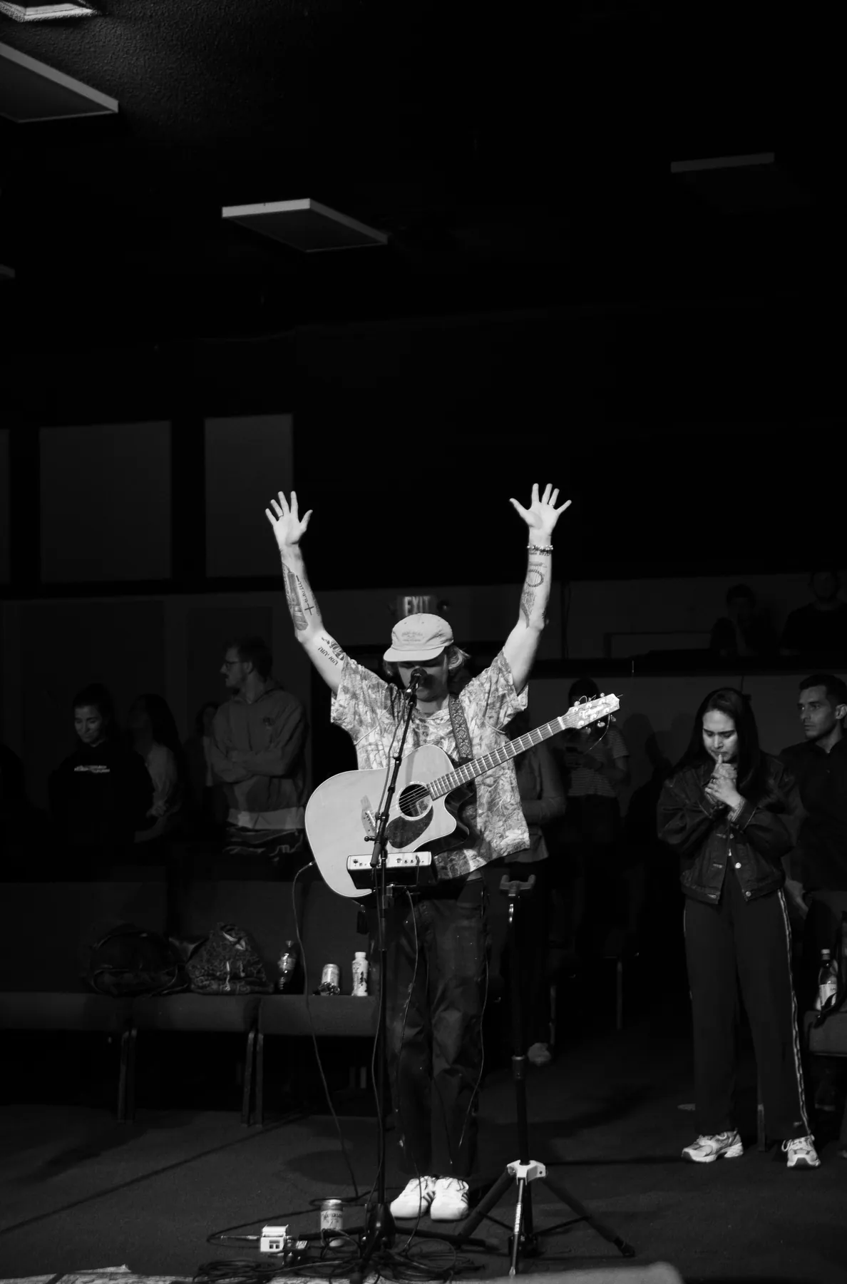 Black and white singer with arms raised on stage