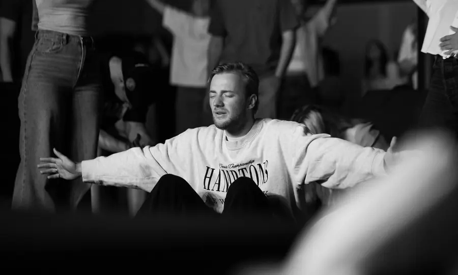 Black and white performer reaching out over the crowd