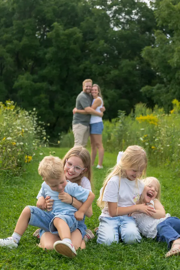 Parents and their children laughing in the grass