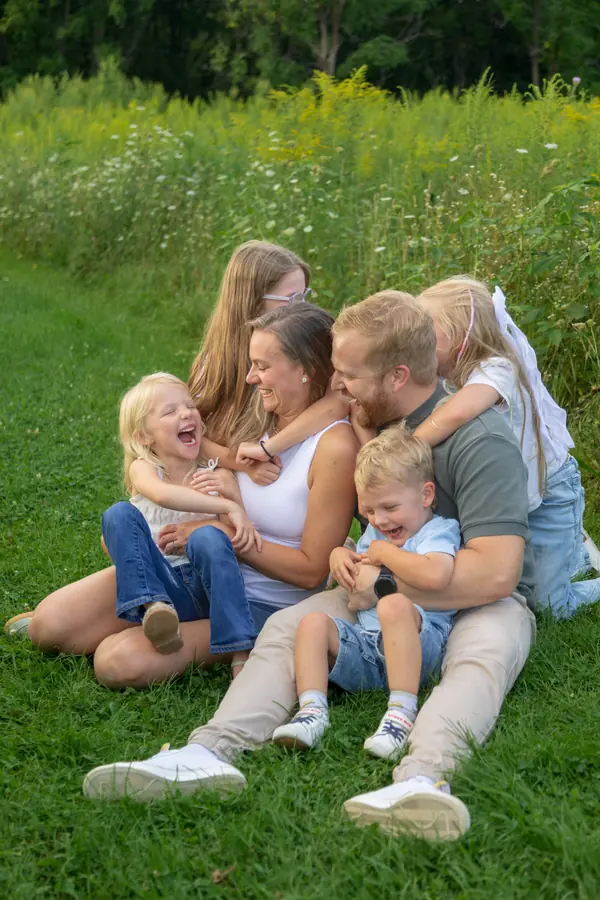 A family piled together in a field of wildflowers