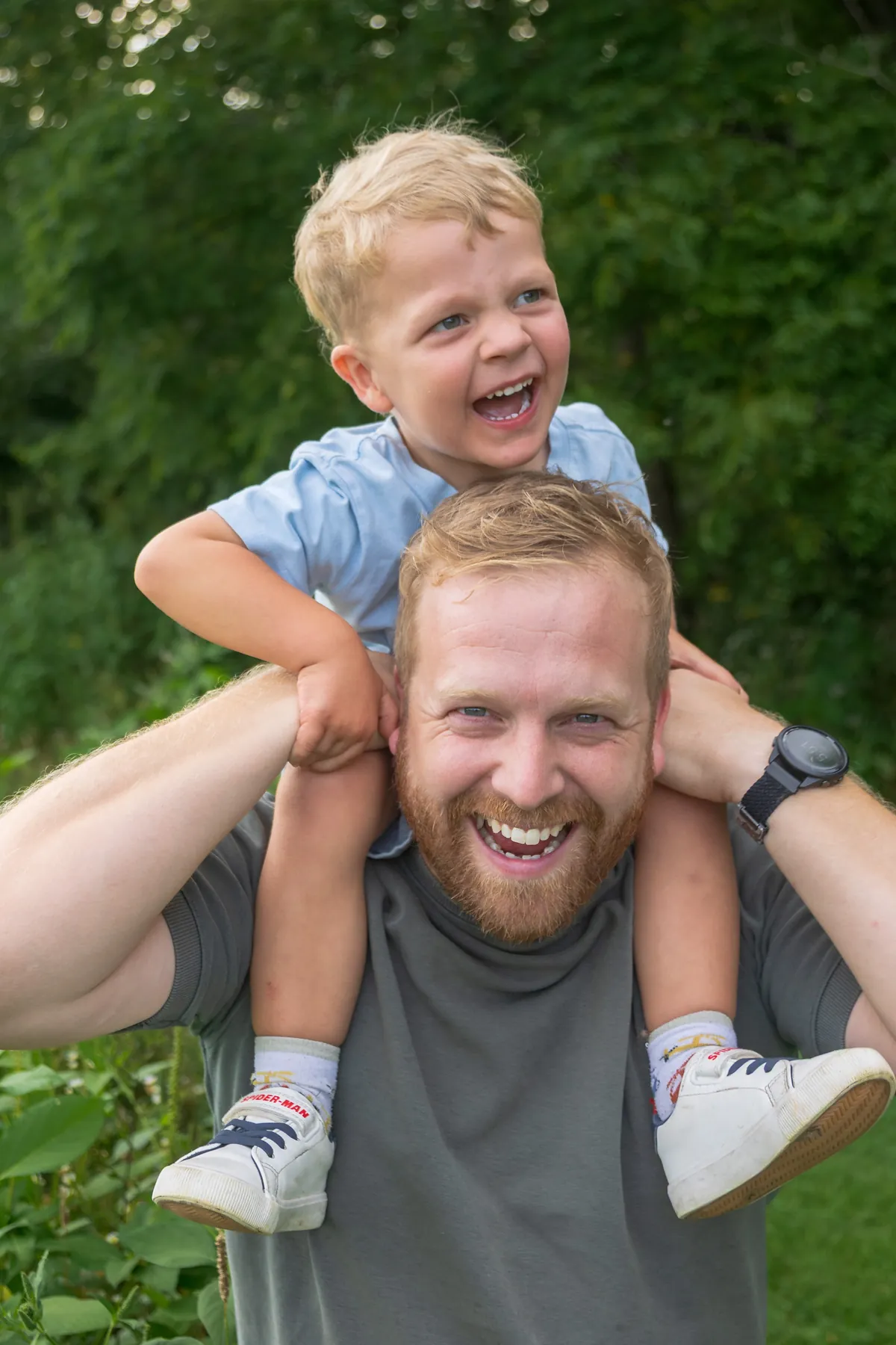 A father carrying his laughing son on his shoulders