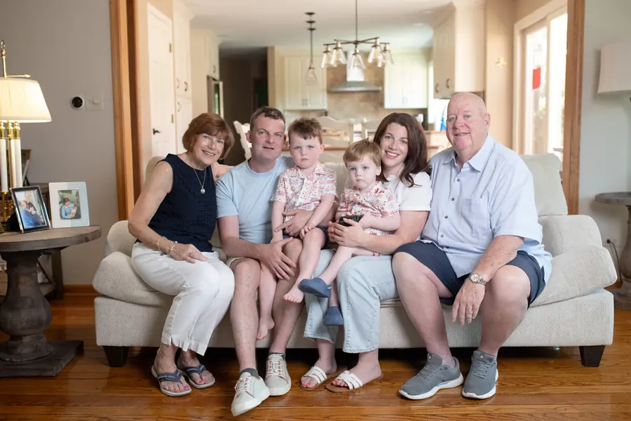 Three generations of a family on a living room sofa