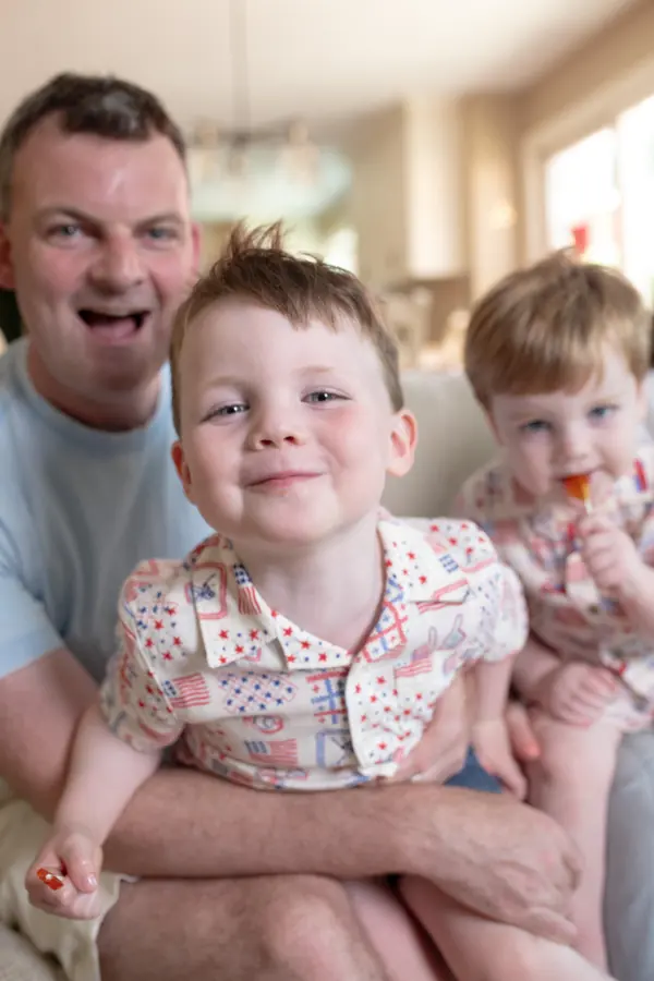 A father and his giggling sons at home