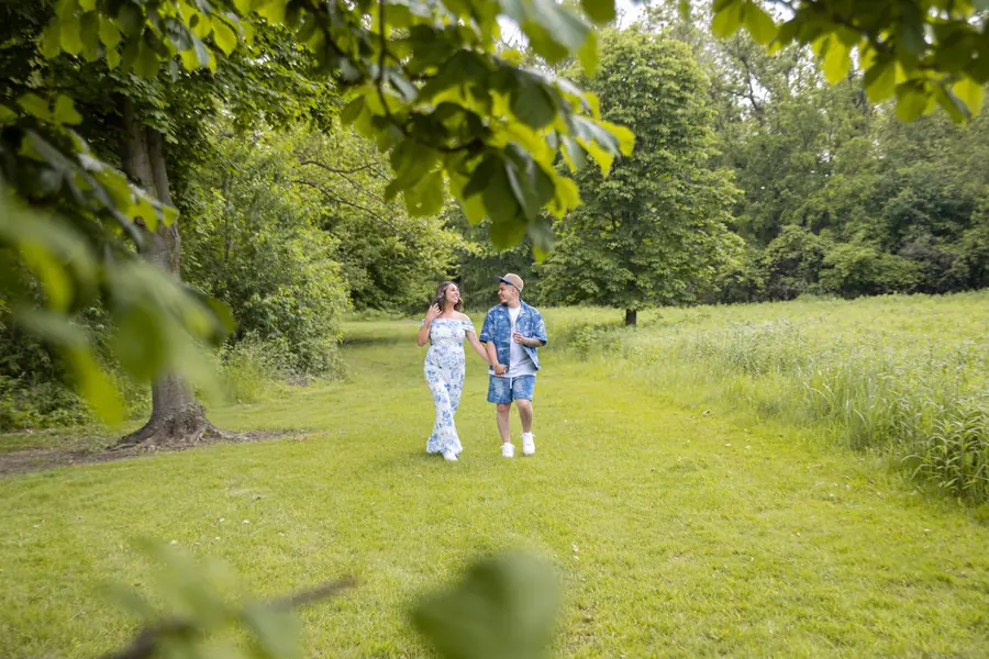 Two children walking hand in hand down a grassy park path