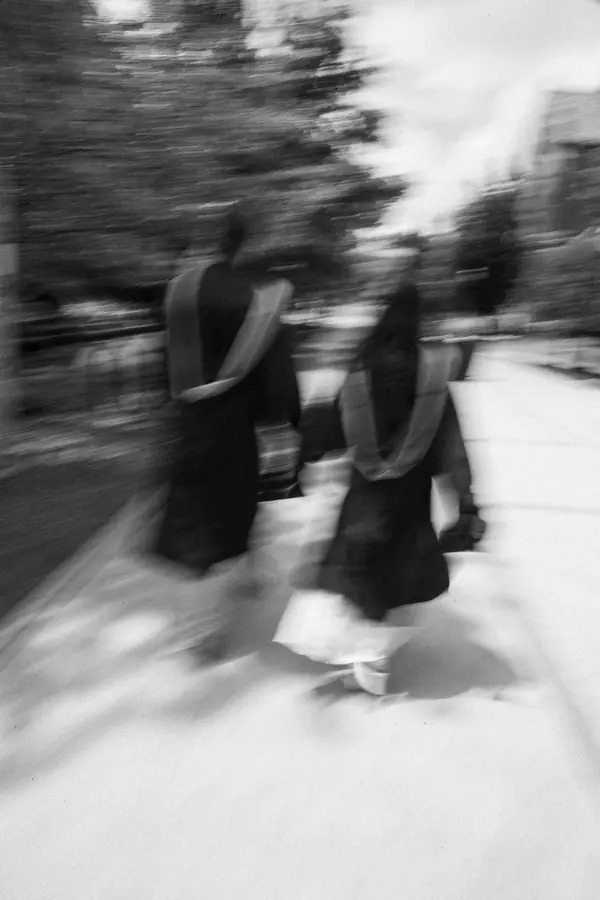 Black and white graduates rushing past in motion blur