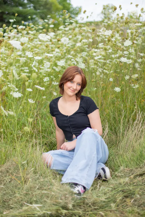 A senior sitting in a field of wildflowers