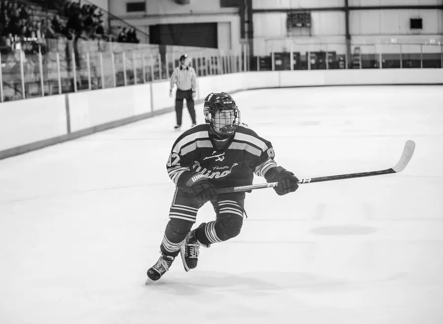 Black and white hockey player skating with the puck
