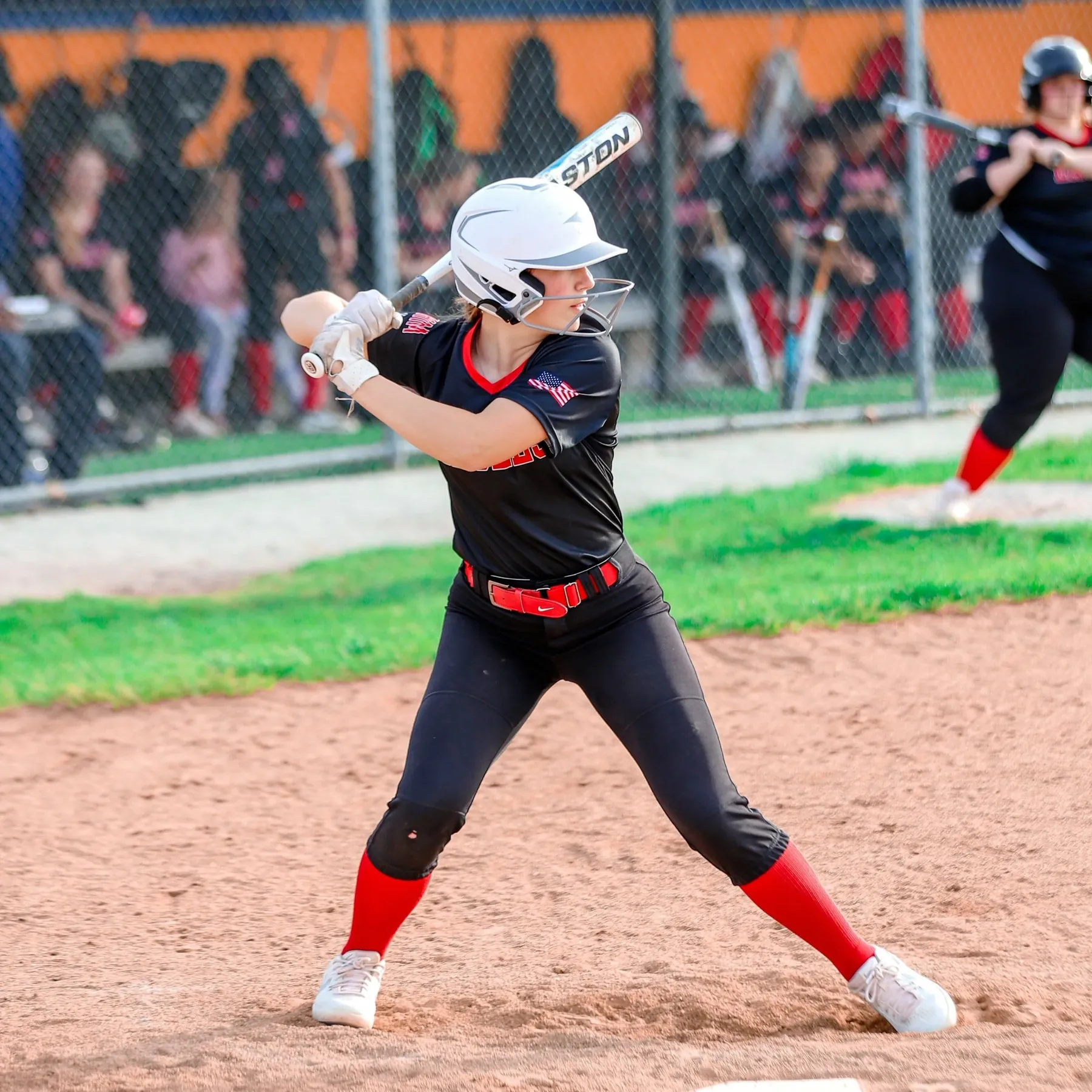 A softball batter mid swing