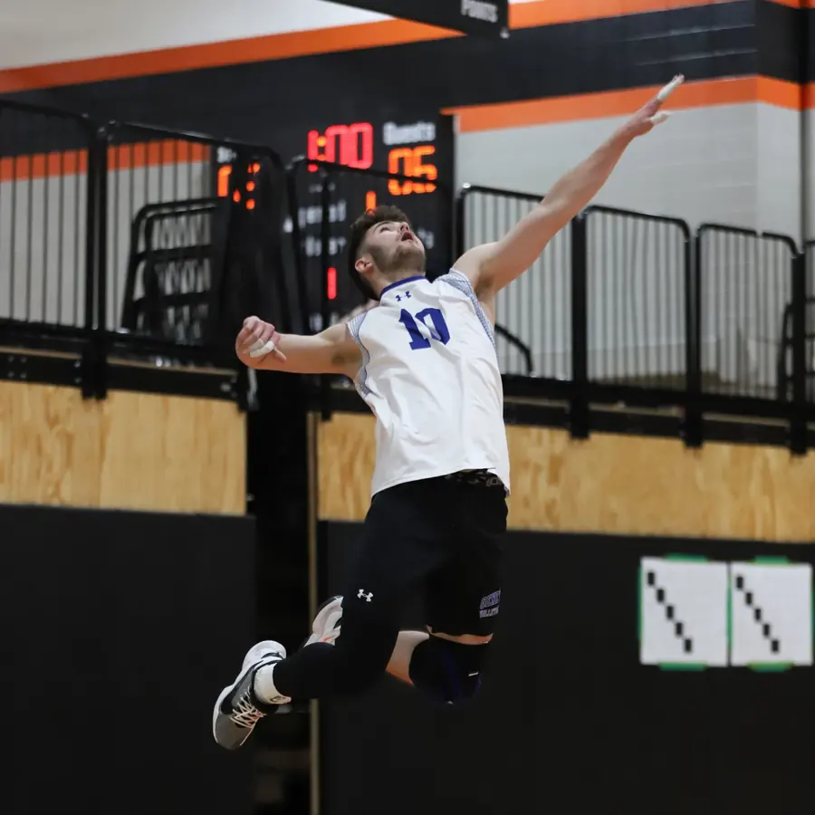 A volleyball player leaping for a spike