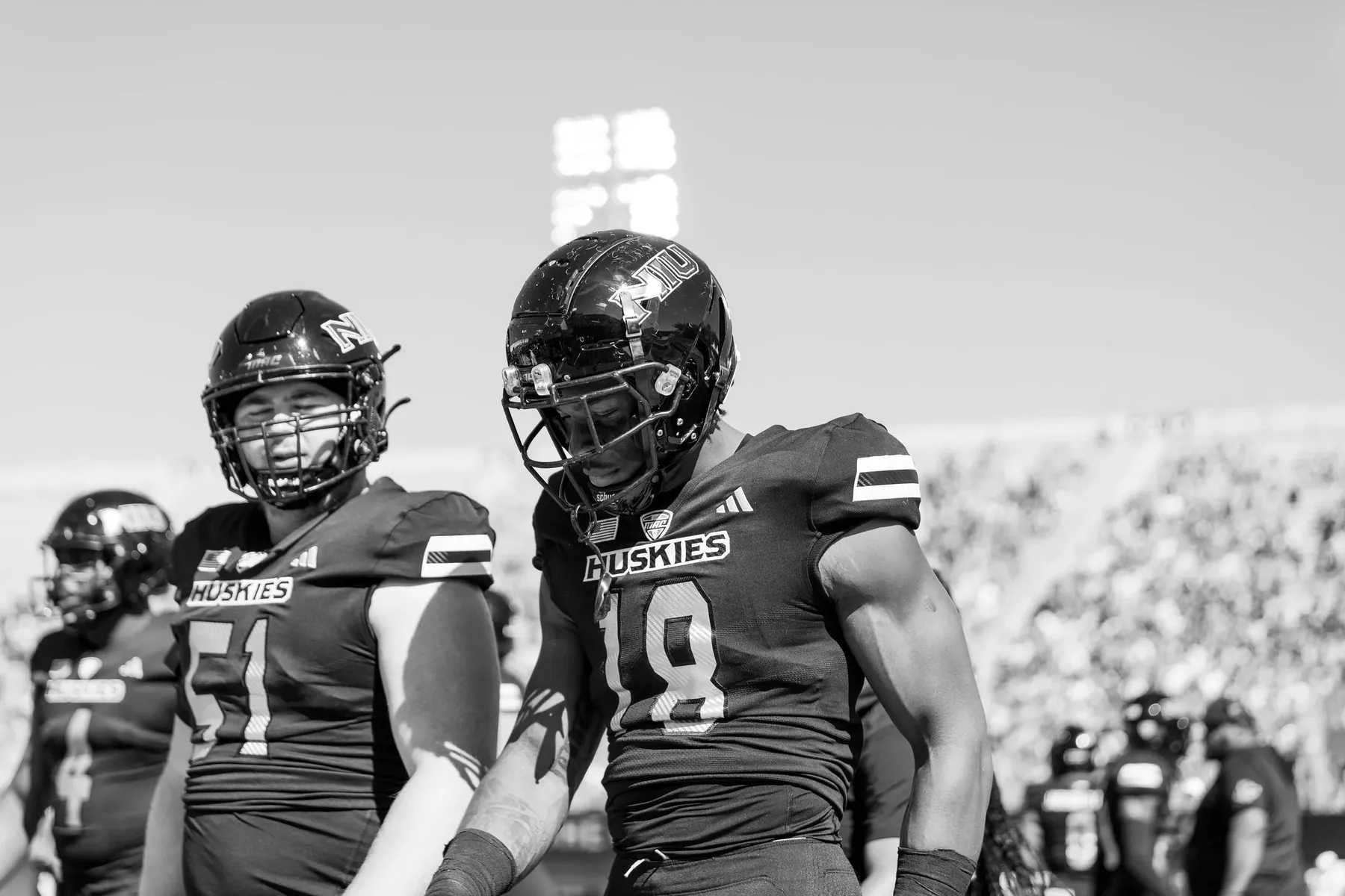 Black and white football players on the sideline