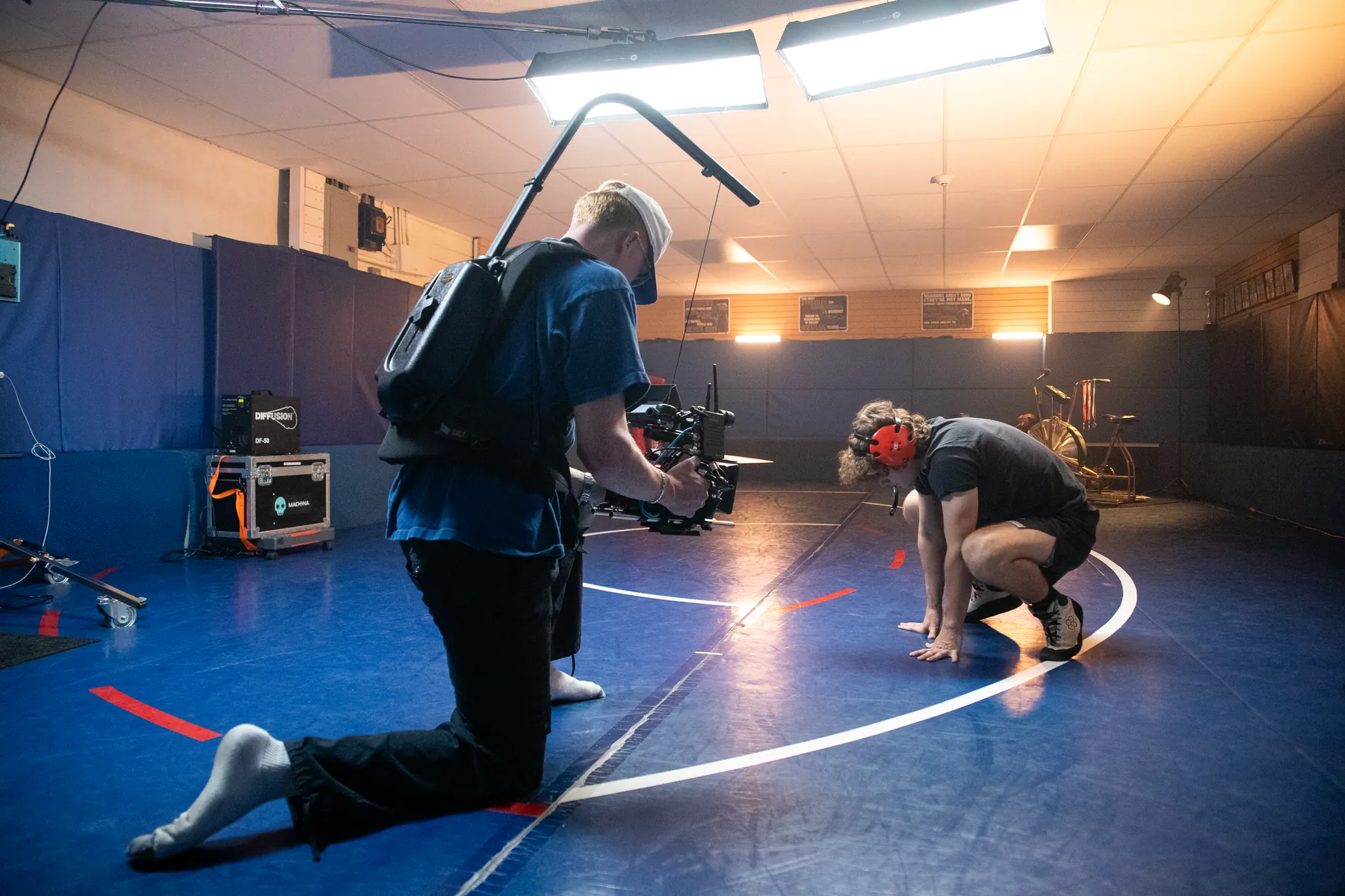 A gimbal operator following a wrestler across the mat