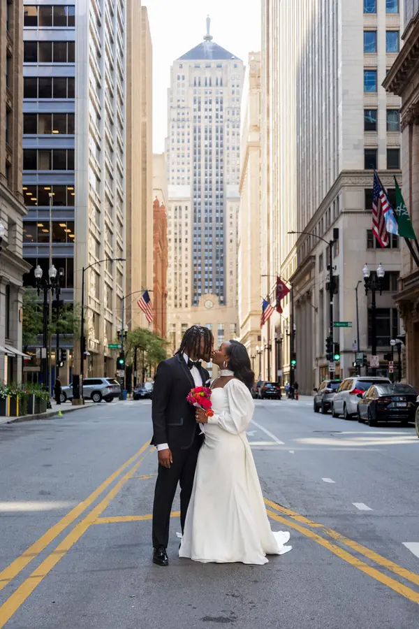 A bride and groom kissing in the middle of LaSalle Street