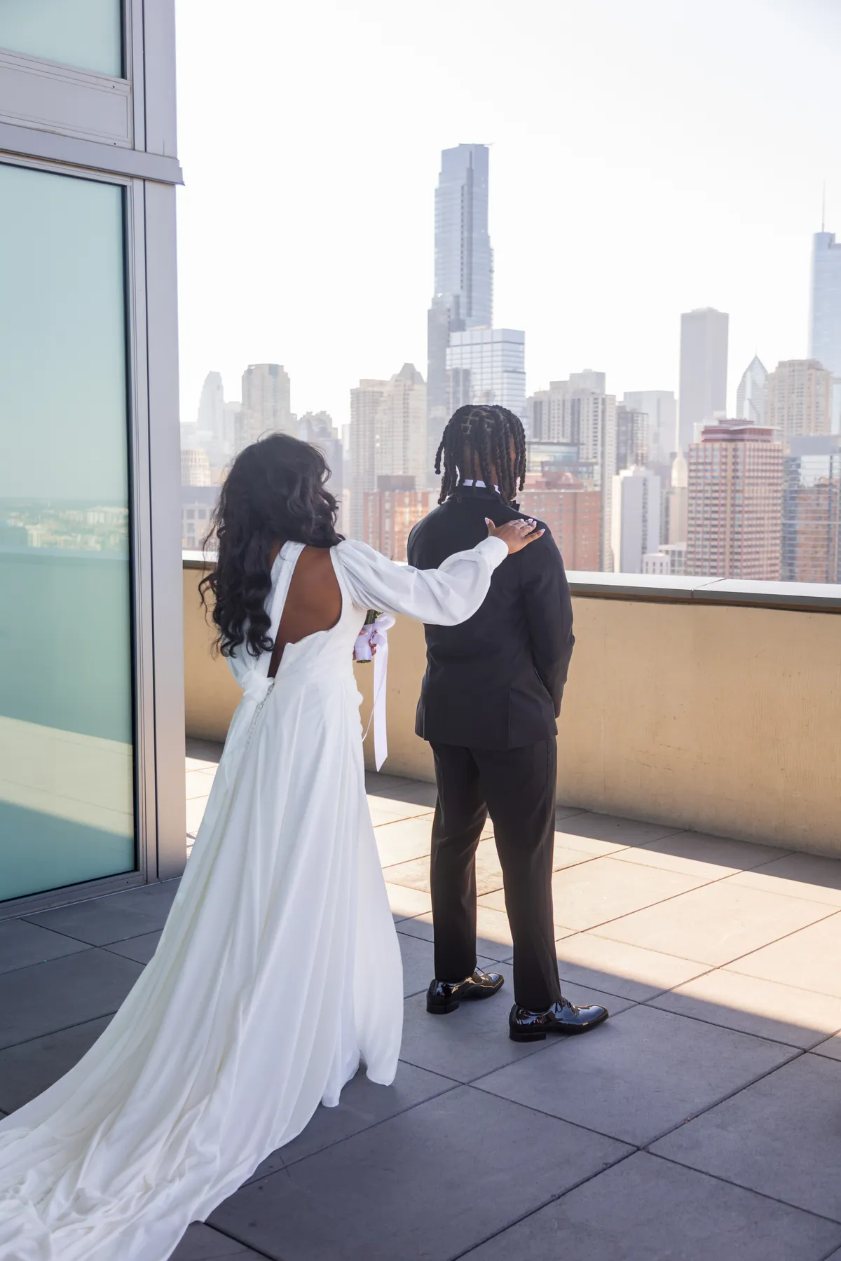 A bride and groom on a rooftop terrace overlooking the skyline