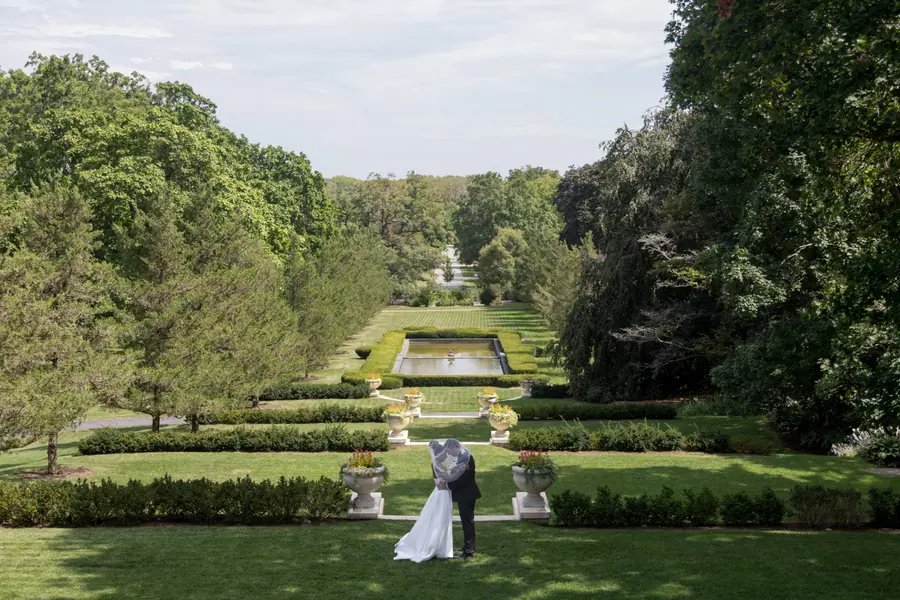 The formal garden from above: long reflecting pool, stone urns, the couple small at the far end