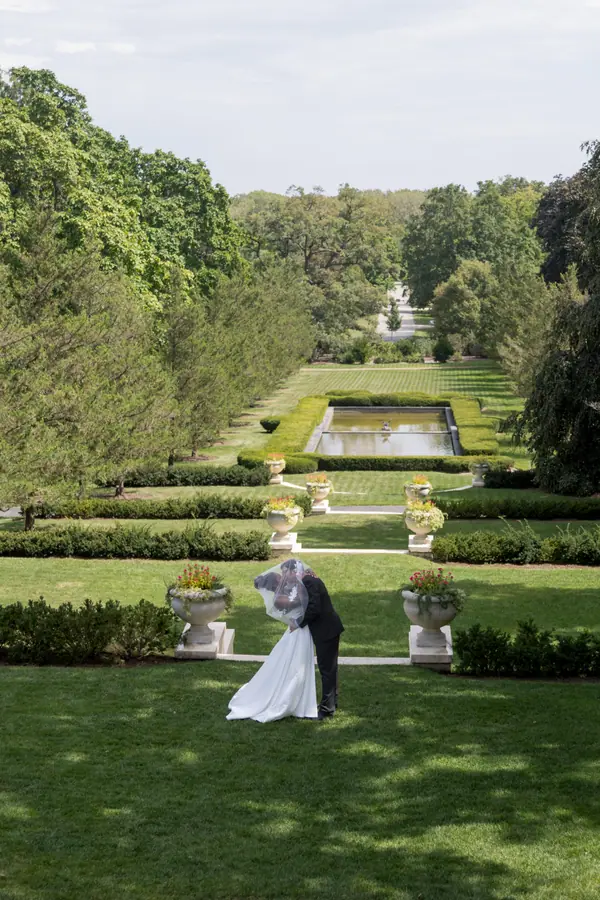 The bride and groom close together on the garden path in the late afternoon