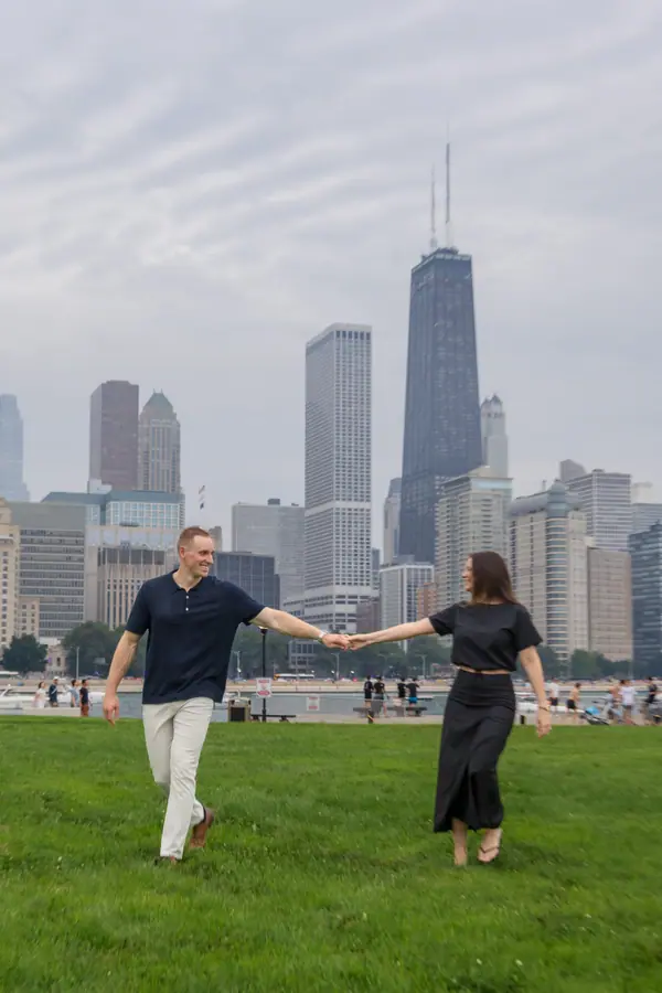 The two of them reaching for each other across the grass with the skyline behind