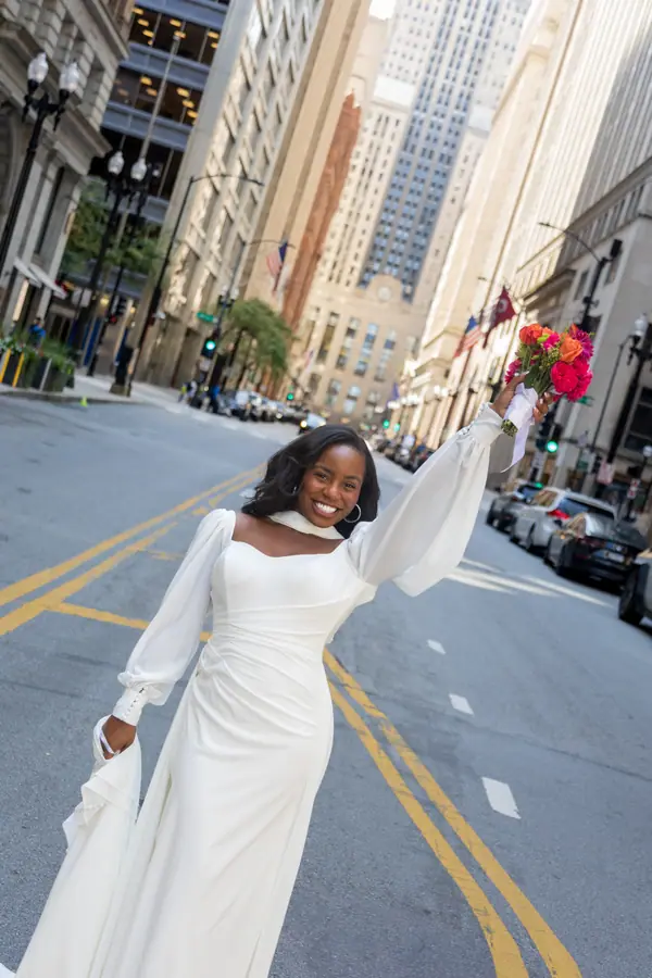 The bride turning back over her shoulder mid stride, her gown catching the afternoon light