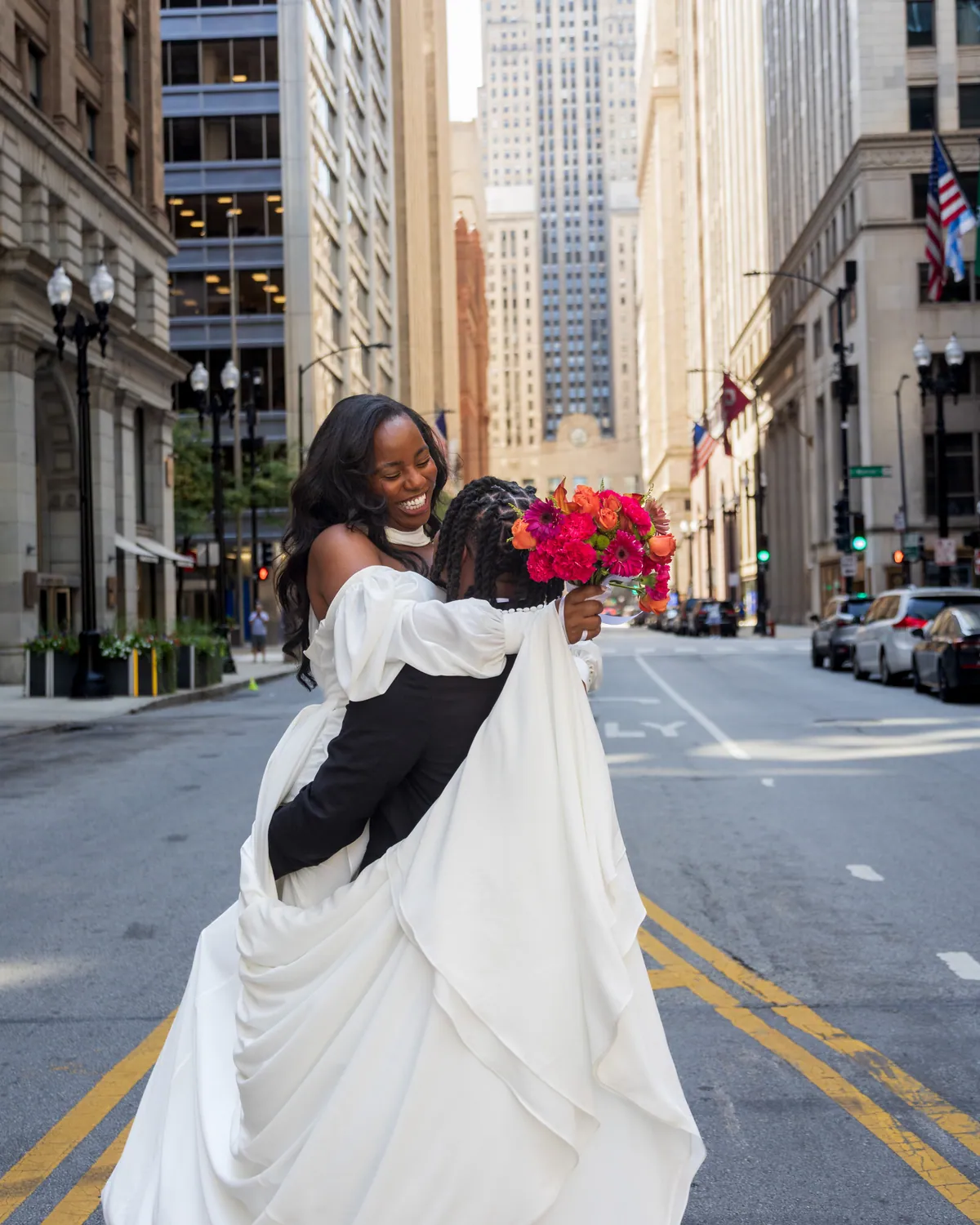 The bride walking down the center line of LaSalle Street, train lifted behind her, the canyon of downtown towers rising on both sides