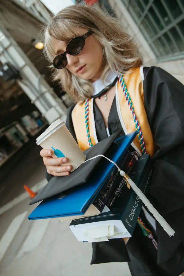 Coffee in one hand, folders under the other arm, crossing the street in full regalia