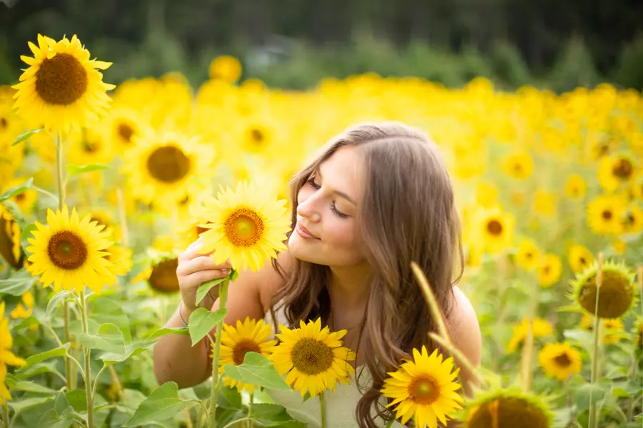 Half turned among the flowers, one hand brushing a bloom