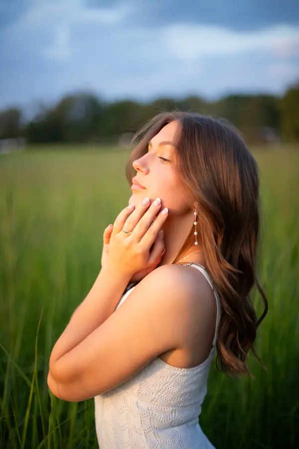 Eyes closed into the warm light at the edge of the prairie grass