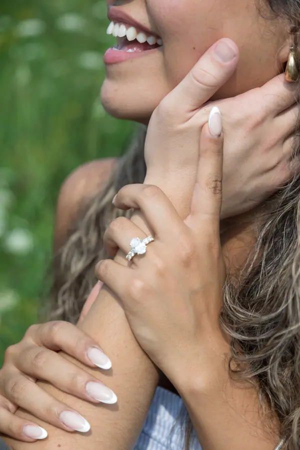 Her hand on his neck with the ring showing, both of them laughing
