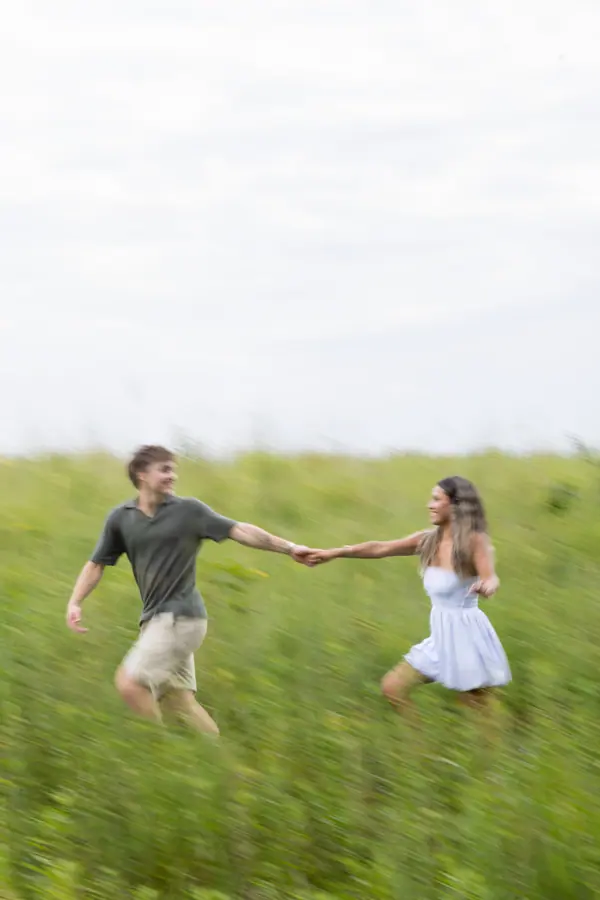 Running toward each other through the long grass, hands nearly touching