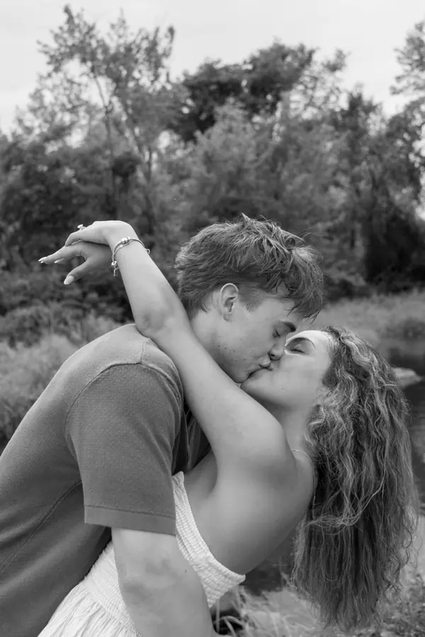 Black and white: he dips her back for a kiss at the top of the field