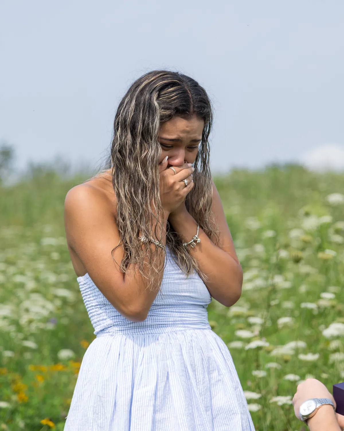 Her hands over her face the moment she realized, standing in a field of white and yellow wildflowers
