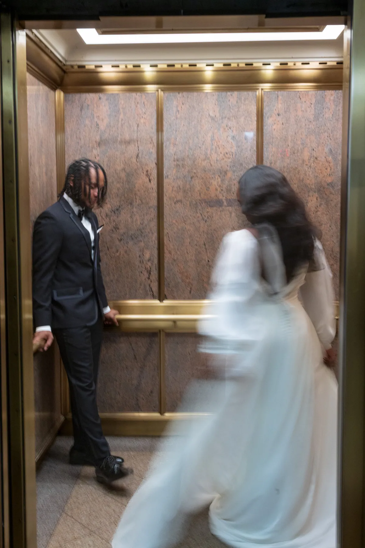 A bride and groom moving through a doorway, the frame blurred with the motion